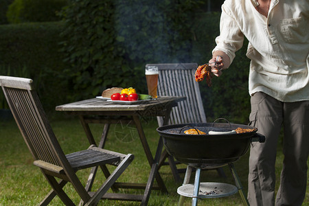 花园里的bbq炙烤牛肉衬衫玉米桌子男人牛扒蔬菜柚木火鸡背景图片