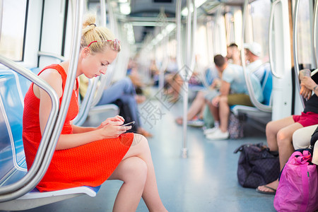 女士乘坐地铁旅行火车女性手机女孩旅游车站铁路商业游客运输座位高清图片素材