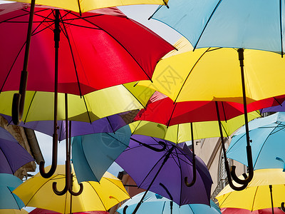 多彩雨伞绿色黄色配饰天气红色天空蓝色庇护所织物阳伞背景图片