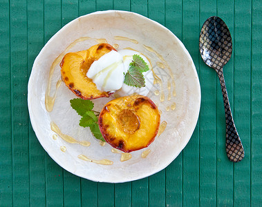 带蜂蜜的甘油桃桃甜点油桃盘子食谱勺子果味食物水果桃子绿色背景图片