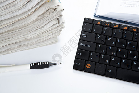 报纸和键盘堆叠静物放大镜白色媒体求职材料新闻商业文档电脑背景图片