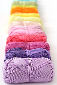 表格上的多彩线衣服缝纫线程紫色绿色创造力桌子织物纺织品针线活背景