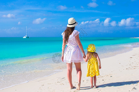 母亲和女儿在热带海滩上行走假期高清图片素材