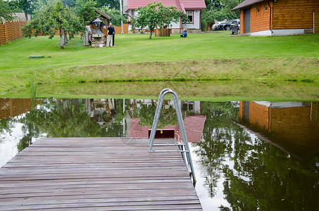 拥有大型木板桥桥村院子的农村池塘背景图片
