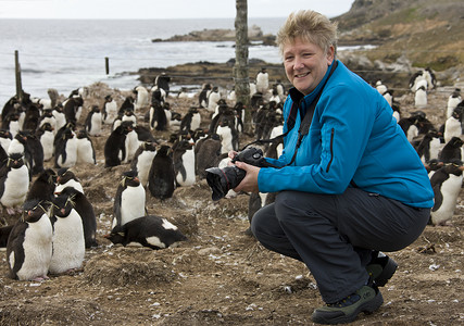 戴着相机企鹅福克兰群岛洛克巴企鹅园区旅游社记者背景