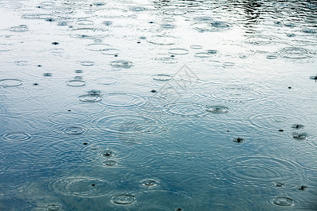 下雨天气风暴飞溅池塘液体反射雨滴涟漪水坑波纹蓝色蓝色的高清图片素材