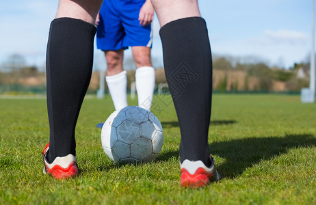 足球运动员对着球场袜子男人竞赛沥青团队闲暇运动服皮革蓝天男性足球靴高清图片素材