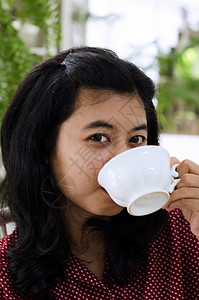 喝杯茶的女人成人快乐幸福青少年白色女性闲暇房子杯子饮料背景