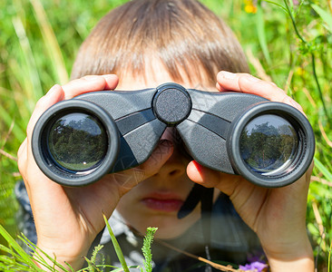 儿童透过望远镜看孩子双目游戏沉思草地眼镜野生动物男生冒险好奇心草原伏击高清图片素材