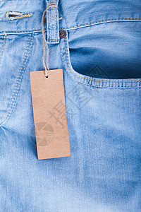 带空白标签的蓝色牛仔裤细节纺织品服装白色牛仔布黄色棉布背景图片