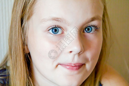 长着大蓝眼睛的可爱女孩女学生金发童年眼睛白色孩子蓝色背景图片