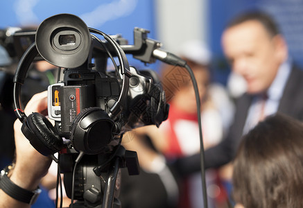 用摄像机拍摄一个活动电视通讯视频行动摄影师记者居住新闻业广播技术会议高清图片素材