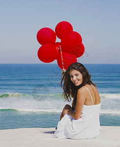 海滩女孩红气球红气球女孩微笑喜悦假期蓝色飞行海洋晴天女士青年乐趣背景