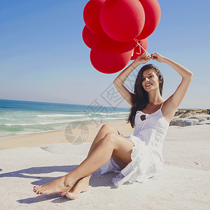海滩女孩红气球红气球女孩海洋蓝色幸福喜悦微笑乐趣晴天享受海滩假期背景