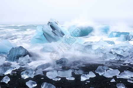 冰岛黑沙滩上的冰石瀑布蓝色冰山沙龙土地海洋冰川时间背景图片