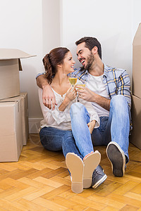 一对可爱的烤面包 和香槟在地板上家园搬迁女性闲暇快乐开箱房地产客厅家庭抵押背景图片
