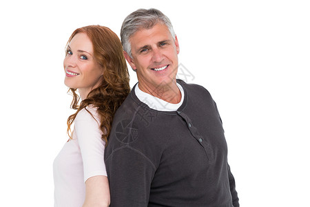 偶然的情侣对镜头微笑夫妻背靠背休闲感情头发红发男性女士快乐女性背景图片