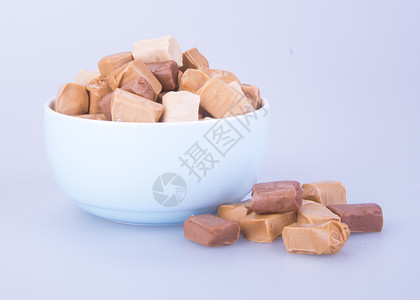 糖果 焦糖糖果 背景上的焦糖糖果 焦糖食物立方体巧克力玻璃小吃棕色糖浆香草白色甜点背景图片