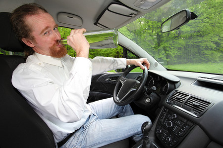 酒醉男人在车里喝着酒瓶酒测试驾驶警察监狱运输酒精速度车辆注意力男性孤独高清图片素材