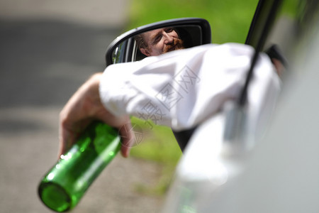 酒醉男人在车里喝着酒瓶酒驾驶人士车辆测试注意力警察瓶子运输汽车男性危险高清图片素材