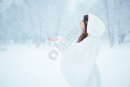 宁静长发女性女士雨披青年下雪戏服白色季节性雪花背景图片