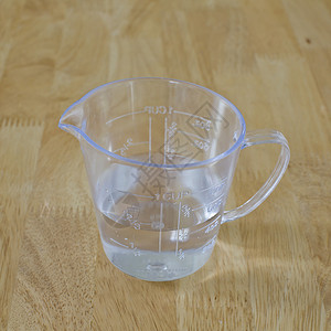 在木本底测量杯子的温水中糕点商品炊具体积立方体牛奶液体水壶厨房烹饪背景图片