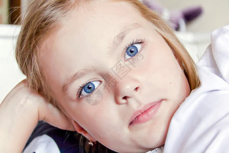 长着大蓝眼睛的可爱女孩眼睛孩子金发女学生童年蓝色白色背景图片