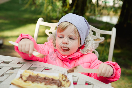 儿童用巧克力吃松饼食物活动微笑女孩午餐花园小吃草地喜悦晴天美丽的高清图片素材
