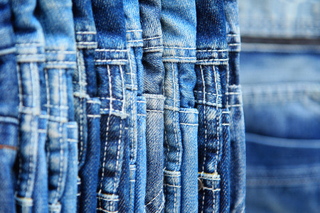 挂挂蓝色牛仔裤列服装裤子壁橱织物纺织品服饰牛仔布裙子衣服零售背景图片
