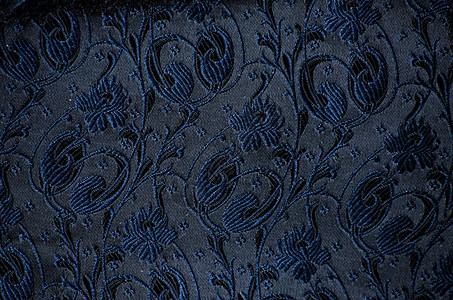 陈年花样的卷纹织物细节丝绸蓝色缝纫漩涡黑色奢华挂毯花朵古董材料背景图片
