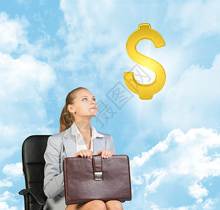 坐在钱上女人坐在办公椅子上的女商务人士 在空中抬头看一看美元标志背景