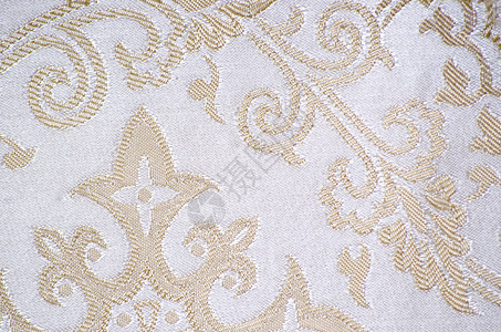 陈年花样的卷纹织物细节奢华花朵白色材料漩涡金子丝绸挂毯缝纫古董背景图片