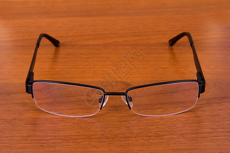 桌上的眼镜影棚木头背景图片