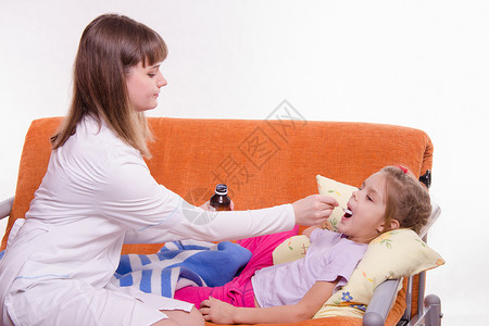 医生用勺子给一个小女孩治病背景图片
