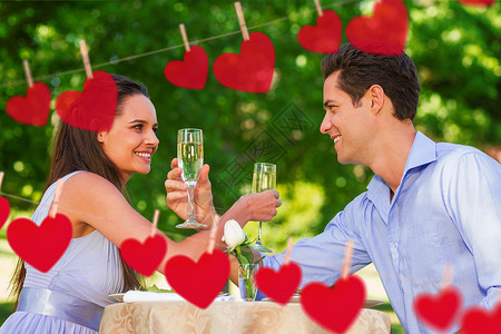 一对夫妇的复合图像 香槟笛子坐在户外咖啡厅情人树木夫妻男性微笑泡酒享受男人酒精长笛背景图片