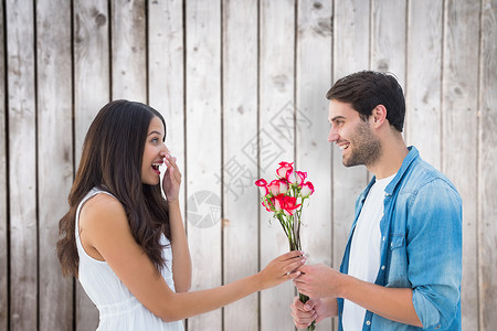 喜悦的潮人给女朋友送玫瑰的复合形象花朵木头胡子裙子头发棕色震惊女士男人女性长发高清图片素材
