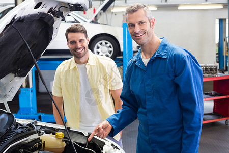 向顾客展示汽车问题 给客户看微笑工程师男性机械师服务男人修理蓝色作坊工人汽车修理高清图片素材