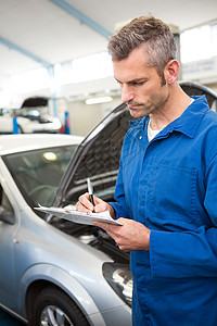剪贴板上的机械写作修理职业机械师专注工作服工人汽车男人蓝色工程师背景图片