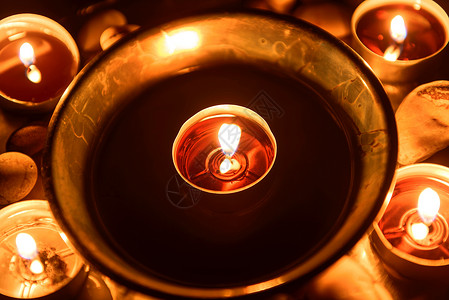 在祭坛上燃烧的蜡烛火焰盘子黑色纪念馆场景教会烛光黑暗圆形金属背景图片