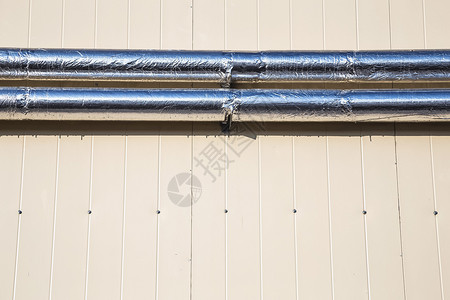 侧墙壁上的金属铬管控制板壁板塑料合金黄色材料条纹聚合物管道背景图片
