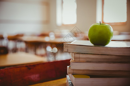 堆积在书本上的苹果学校小学图书课堂背景图片