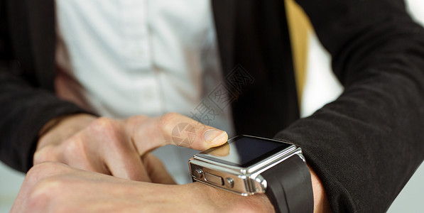 利用聪明手表的女商务人士电脑商务套装移动手腕智能技术商业女性女士背景图片