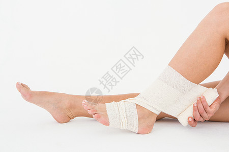 坐在坐着的女士系脚踝痛苦身体包扎跟腱疾病疼痛背景图片