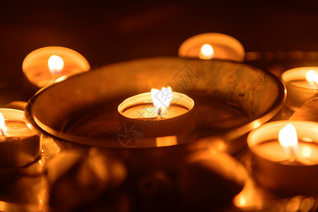 在祭坛上燃烧的蜡烛烧伤火焰仪式金属烛光黑色圆形教会白色盘子背景图片