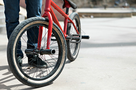 自行车轮胎BMX 自行车驾驶机男生红色轮胎青少年闲暇孩子滑冰运动鞋公园牛仔裤背景