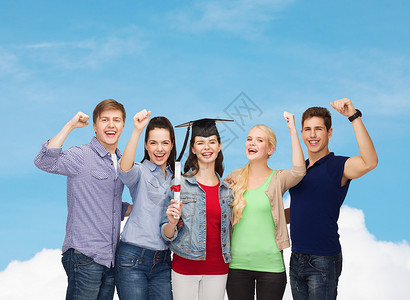 持有文凭的微笑学生群体站立快乐大学朋友们砂浆流苏天空女孩帽子正方形同学男孩们高清图片素材