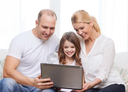 家里有笔记本电脑的父母和小女孩互联网女性妈妈父亲女儿青少年技术男人成人母亲爱高清图片素材