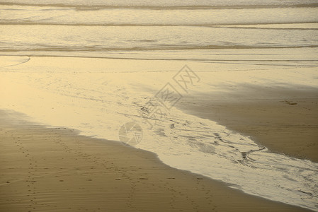 沙子上水的形态海滩曲线橙子流动海岸辉光背景图片