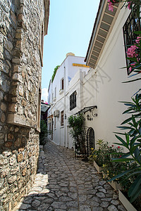 窄街蓝色火鸡石头街道石墙小路晴天环境白色房子背景图片