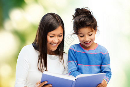 幸福的母亲和小女儿阅读书本微笑学前班童年快乐教育妈妈女性童话教学生态背景图片